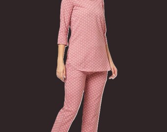 May include: A two-piece lounge set consisting of a long-sleeved top and matching trousers in a dusty rose colour. The fabric features a repeating white geometric pattern throughout. The top has a V-neckline and three-quarter length sleeves.