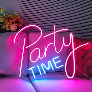 May include: A neon sign in a cursive font that reads "Party TIME". The sign is outlined in bright pink and blue neon lights. The sign is placed against a backdrop of a striped wall and a sofa.