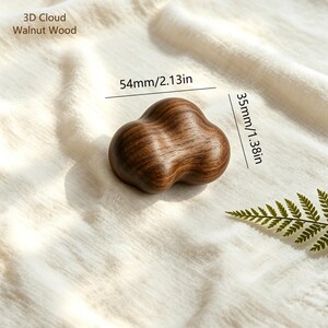 May include: A 3D cloud-shaped object crafted from dark walnut wood. The item features a smooth, rounded surface with visible wood grain patterns. Text on the image indicates dimensions of 54mm/2.13in in width and 35mm/1.38in in height for this piece.