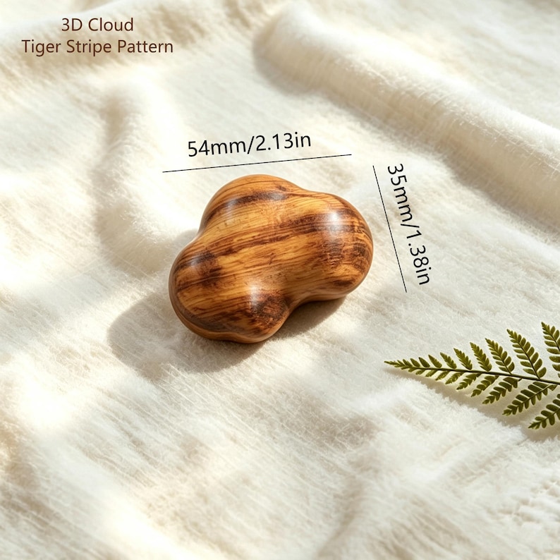 May include: A 3D cloud-shaped object with a tiger stripe pattern, measuring 2.13 inches in width and 1.38 inches in height. The object features a smooth, polished wooden texture with dark brown grain lines running horizontally across the surface.