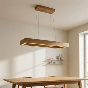 Puede incluir: Una lámpara colgante rectangular de madera con un acabado de veta natural. Cuenta con una fuente de luz LED lineal empotrada. La lámpara está suspendida del techo por finos cables, sobre una mesa de comedor de madera.