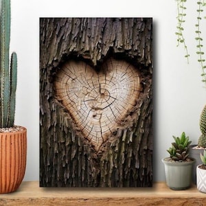 May include: A wooden wall art piece featuring a heart-shaped design carved into a tree trunk. The heart is made of light brown wood, surrounded by dark brown bark. The artwork is displayed on a wooden shelf with potted plants.