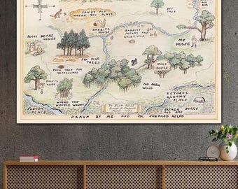 May include: A framed map illustration of a whimsical landscape with text labels like "Pooh Bears House" and "100 Aker Wood." The artwork features a compass rose and is in a vintage style with soft colors.