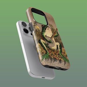 May include: A phone case featuring a vintage illustration of a green frog playing a banjo. The case has a brown and tan background with a black border. The phone case is shown with a silver phone.