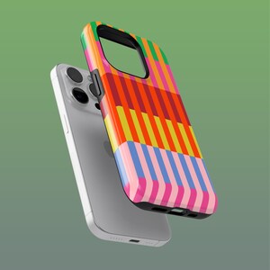 Könnte beinhalten: Ein silbernes Smartphone mit einer farbenfrohen Handyhülle. Die Hülle hat vertikale Streifen in Orange, Gelb, Rosa, Blau und Grün. Die Hülle ist leicht vom Telefon getrennt und zeigt die Kamera und die Tasten.