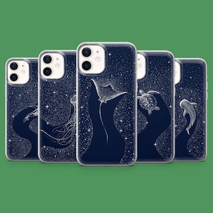 May include: A set of navy blue phone cases with white illustrations of marine creatures, such as a manta ray, jellyfish, turtle, and shark. The cases have a starry night sky design.