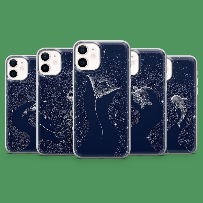 May include: A set of navy blue phone cases with white illustrations of marine creatures, such as a manta ray, jellyfish, turtle, and shark. The cases have a starry night sky design.
