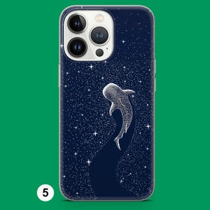 May include: A navy blue phone case with a white illustration of a whale shark against a starry night sky. The case has a clear border and a camera cutout.