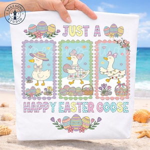 May include: White Easter-themed towel featuring three cartoon geese in pastel frames with Easter eggs and floral accents. Text reads "JUST A" and "HAPPY EASTER GOOSE". The towel is held up on a beach.