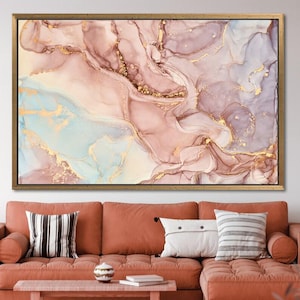 May include: Abstract art print in a gold frame. The artwork features flowing patterns in shades of pink, purple, and blue, accented with gold metallic details. The piece is a canvas print.