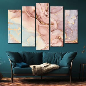 May include: Five-panel abstract art piece with a fluid design in shades of pink, gold, and blue. The artwork features a marble-like effect with gold accents, creating a luxurious and modern aesthetic. The panels are displayed above a teal sofa.