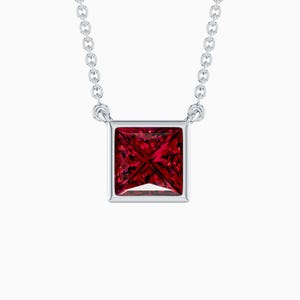 May include: A silver necklace with a square, deep red gemstone pendant. The pendant is set in a square frame and hangs from a delicate chain. The gemstone has multiple facets, reflecting light. The jewellery is displayed against a white background.
