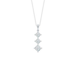May include: A silver necklace with three square-cut, sparkling gemstones suspended in a vertical line. The pendant hangs from a delicate chain, creating a simple yet elegant design. The gemstones appear to be diamonds.