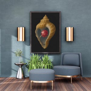 May include: A framed artwork depicts a seashell with a red gemstone ring inside, set against a black background. The artwork hangs on a teal wall, complemented by a blue chair, ottoman, and gold-toned accents. Decorative wall sconces flank the artwork.