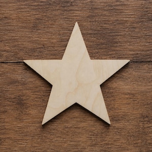 Può includere: Una stella a cinque punte ritagliata in legno chiaro e liscio con un visibile motivo a venature naturali. La stella presenta punte affilate e simmetriche e una superficie piatta, che mostra le tonalità beige chiaro del legno non rifinito.