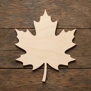 Può includere: Una sagoma in legno di colore chiaro a forma di foglia d'acero. L'oggetto presenta una superficie liscia con venature del legno naturali, lobi appuntiti distinti e un unico stelo che si estende dal basso, mostrando un design pulito e simmetrico.