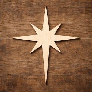 Può includere: Una stella ritagliata in legno chiaro e piatto, caratterizzata da un classico design a otto punte con raggi verticali e orizzontali allungati. La stella presenta una finitura liscia con venature del legno naturali e punte affilate, creando una forma geometrica simmetrica.