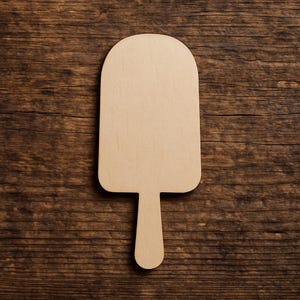 Puede incluir: Un recorte de madera de color claro en forma de paleta, con una parte superior redondeada y un mango de palo. El recorte se encuentra sobre un fondo de madera oscura y texturizada. Ideal para proyectos de bricolaje.