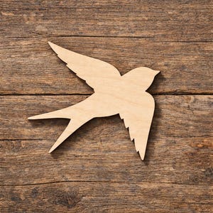 Könnte beinhalten: Holzausschnitt einer Schwalbe im Flug. Der hellbraune Vogel hat ausgebreitete Flügel und einen gegabelten Schwanz. Der Hintergrund besteht aus verwitterten, dunkelbraunen Holzplanken.