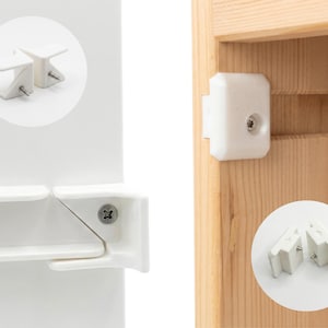 May include: White child safety cabinet locks and drawer latches. The image shows the locks installed on a white cabinet and a wooden cabinet. The locks are designed to prevent children from opening cabinets and drawers.