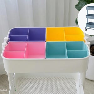 May include: A white plastic storage organizer insert with four distinct sections in purple, yellow, pink, and light blue. Each section is divided into smaller compartments. The text "Inserts only Cart not included" is visible at the bottom left.