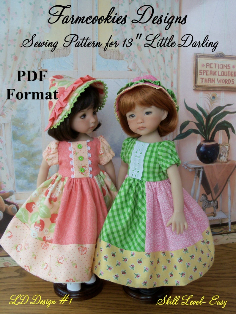 May include: Two 13 inch dolls wearing dresses and hats. The doll on the left is wearing a pink and green dress with a strawberry print and a pink and green hat. The doll on the right is wearing a green and pink gingham dress with a yellow and pink floral print and a red and green hat. The text "Farmcookies Designs" is at the top of the image. The text "Sewing Pattern for 13" Little Darling" is below the title. The text "PDF Format" is in the lower left corner of the image. The text "LD Design #1" is in the lower left corner of the image. The text "Skill Level- Easy" is in the lower right corner of the image.