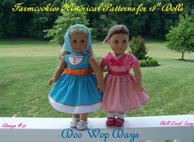 May include: Two 18-inch dolls wearing vintage-inspired dresses. The doll on the left is wearing a blue and white gingham dress with an orange sash and a light blue bonnet. The doll on the right is wearing a pink dress with white polka dots and a pink bow. The dolls are standing on a white surface with the text "Doo Wop Days" and "Design #48" visible. The background is a green grassy area with trees.