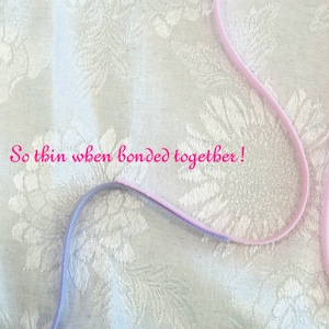 May include: A close-up of two thin, flexible cords, one lavender and one pink, against a white floral patterned fabric. The text "So thin when bonded together!" is written in pink.