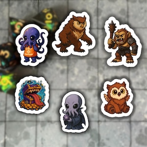 Puede incluir: Un conjunto de pegatinas con temática de fantasía con varias criaturas. Incluye un pulpo con un delantal con el texto "Crit Happens", un búho marrón, una criatura parecida a un oso con un garrote, un cofre del tesoro, un alien gris y un pequeño búho.