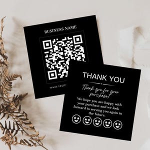Op de afbeelding: Twee zwarte vierkante kaarten met witte tekst. Eén kaart heeft een QR-code en de tekst "BUSINESS NAME" en "www.reall". De andere kaart zegt "THANK YOU" en "Thank you for your purchase!" met smiley's.