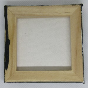 Puede incluir: Un peque&ntilde;o marco de madera para lienzo con un lienzo blanco estirado en su interior. El marco est&aacute; pintado de negro en los bordes.