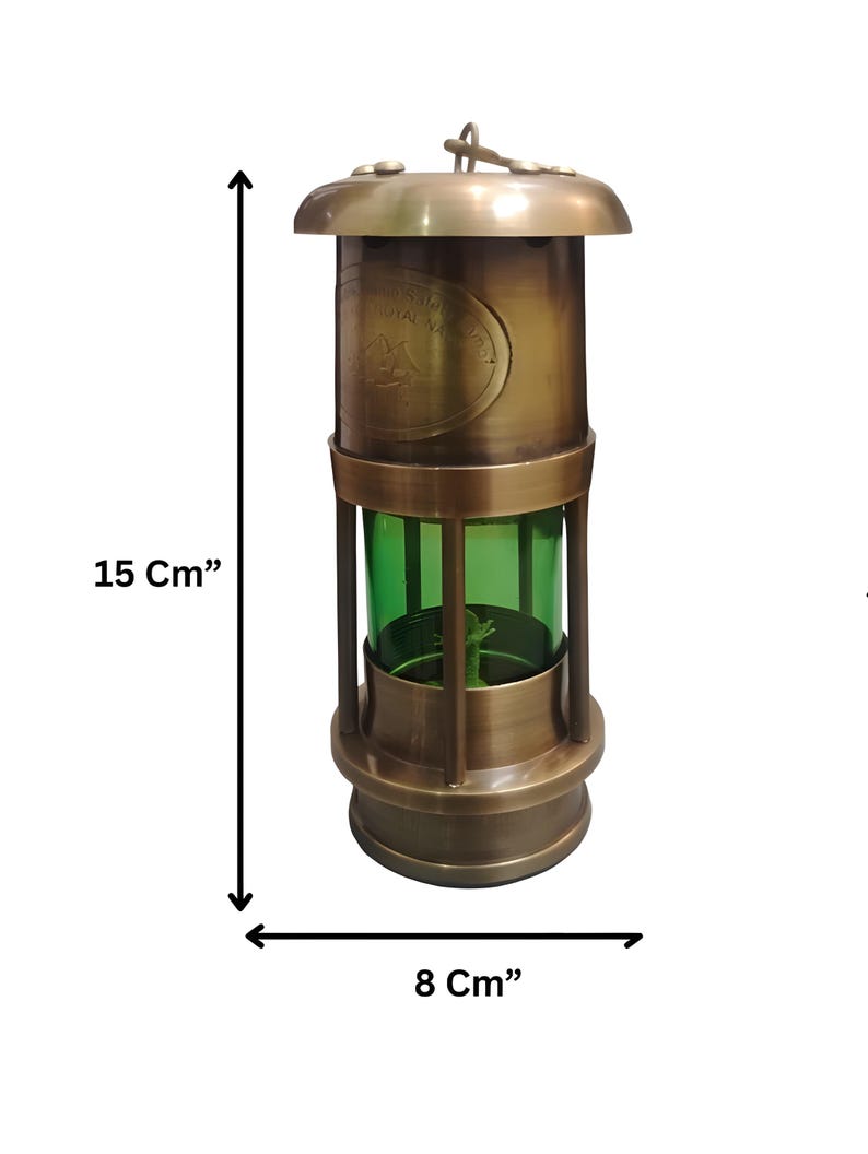 Op de afbeelding: Een vintage messing lantaarn, 15 cm hoog en 8 cm breed, met een groene glazen behuizing. De lantaarn heeft een ronde boven- en onderkant en een handvat. De tekst "ROYAL NAVY" is zichtbaar op de zijkant.