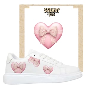 May include: White trainers with pink heart and bow designs. The shoes feature a large pink heart with a lace bow on the side, and smaller heart and bow designs on the shoe's exterior. The text "Sneaky Tats" is at the top.