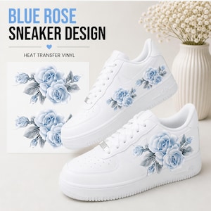 May include: White sneakers with a blue rose design. The shoes feature a floral pattern on the sides and a matching design on a separate sheet. The text "BLUE ROSE SNEAKER DESIGN" and "HEAT TRANSFER VINYL" are visible.
