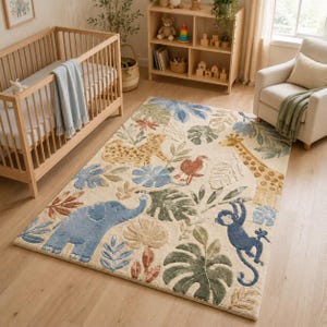 May include: A rectangular area rug featuring a cream-colored background with a tufted jungle theme. The design includes a blue elephant, a yellow giraffe, a spotted leopard, and a blue monkey surrounded by various green, blue, and brown leaves.