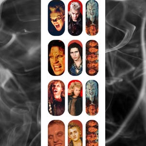 May include: Nail art featuring images of characters from the movie "The Lost Boys." The nail art includes images of vampires with fangs, and the text "A Touch of Evil" is at the top and bottom of the design.