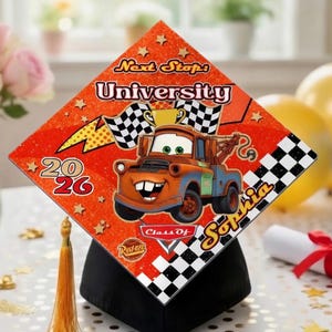 May include: A graduation cap with a bright orange design featuring the character Mater from the film Cars. The cap includes the text "Next Stop: University", "2026", and the name "Sophia". A gold tassel hangs from the cap.