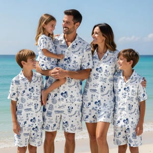 Może przedstawiać: Rustykalny drewniany znak z napisem "Welcome" w stylu ręcznym. Znak jest pomalowany na biało i ma małe, dekoracyjne serce. Tło to rozmyte zdjęcie domu.