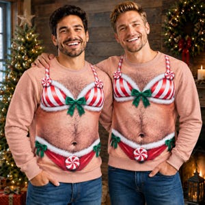 May include: A light tan crewneck sweatshirt featuring a realistic printed graphic of a hairy torso wearing a red and white striped candy cane bikini with white faux fur trim, green bows, and peppermint candy accents on the bra and bikini bottoms.