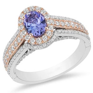 May include: An oval-cut, light purple gemstone ring with a halo of small white diamonds. The ring has a split shank design with additional small diamonds and rose gold accents. The band is silver-colored.