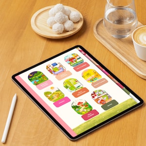 Op de afbeelding: Een digitale tablet met een plannerinterface met secties zoals "Dagelijkse planner" en "Maaltijdplanner". Het scherm heeft een roze rand. Een witte stylus ligt op het houten oppervlak. Een klein bord met kokosballen en een glas water zijn ook zichtbaar.