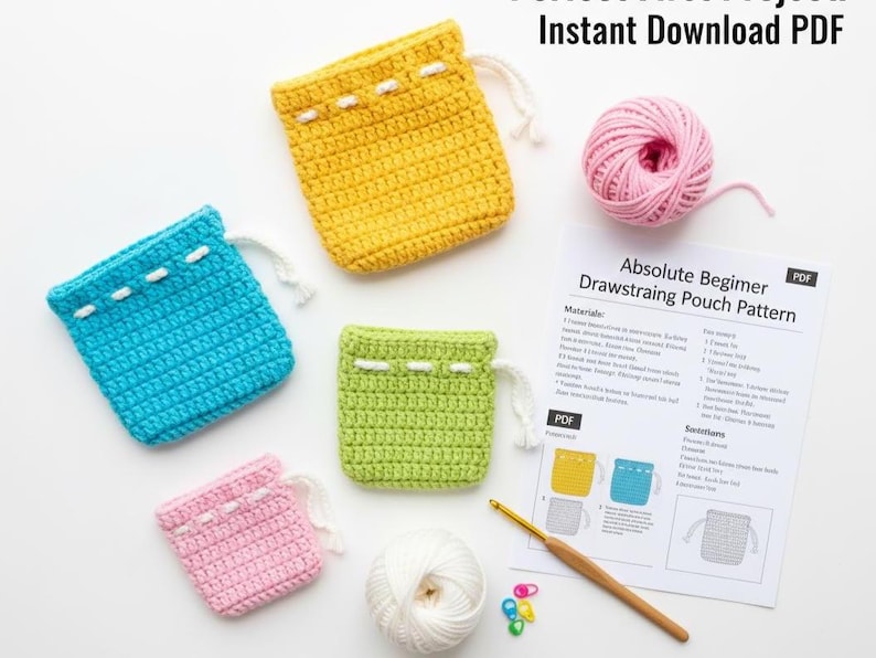 May include: A selection of brightly coloured, crocheted drawstring pouches in yellow, blue, green, and pink. Each pouch has a white drawstring and is shown with yarn, a crochet hook, and a pattern sheet. The text "Instant Download PDF" is visible.