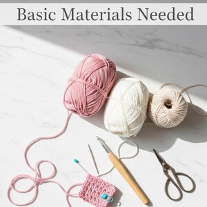 May include: A top-down view shows crochet supplies. Three balls of yarn in pink, white, and beige are alongside a crochet hook, scissors, and a small crocheted square. The text "Basic Materials Needed" is at the top of the image.