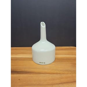 May include: A white ceramic laboratory funnel with a long, slender neck and a wide, cylindrical base. The funnel has a smooth, glossy finish and is marked with "100mm" on the base. It is designed for transferring liquids.