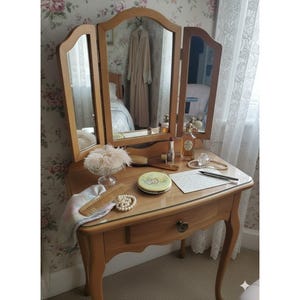 Op de afbeelding: Een witte keramische mok met een zwart handvat en de tekst "But First, Coffee" in een zwarte, vette letter. De mok staat op een houten oppervlak. De mok lijkt ongeveer 355 ml te bevatten.