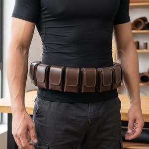Boba Fett utility belt cosplay inspired by the legendary Star Wars bounty hunter featuring detailed pouches, utility compartments, and Mandalorian-inspired design. This cosplay belt accessory is perfect for Boba Fett costumes, Mandalorian builds, Comic Con, Halloween, cosplay conventions, and Star Wars fan events. The bounty hunter belt includes screen-inspired styling, durable construction, and comfortable wear, making it ideal for cosplay photography, collector displays, costume upgrades