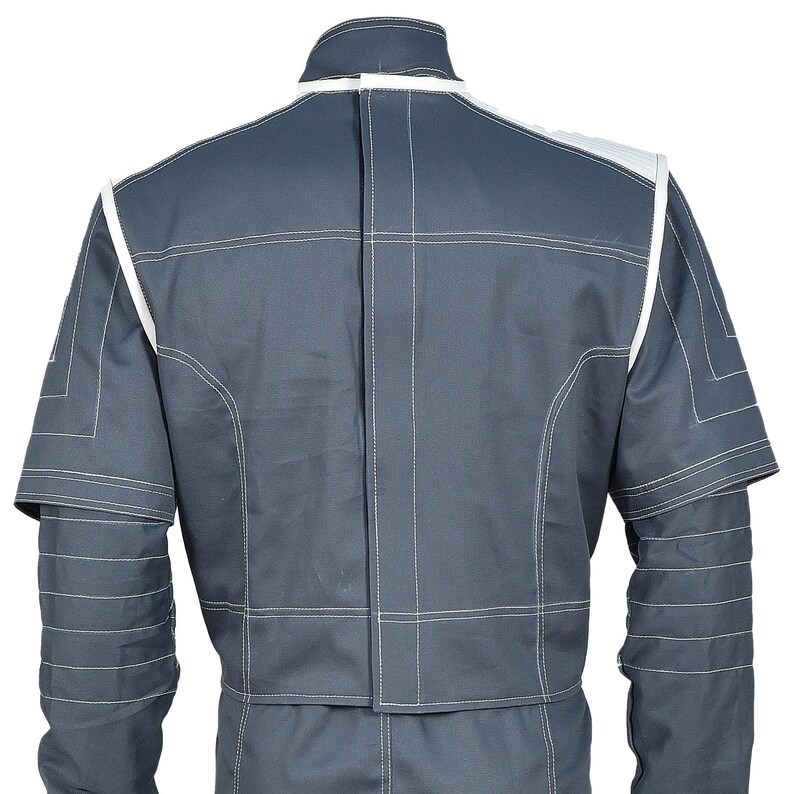May include: A gray jumpsuit with white trim and stitching. The back view shows a high collar, shoulder accents, and detailed stitching patterns. The jumpsuit has short sleeves and a tailored fit, suitable for various activities.