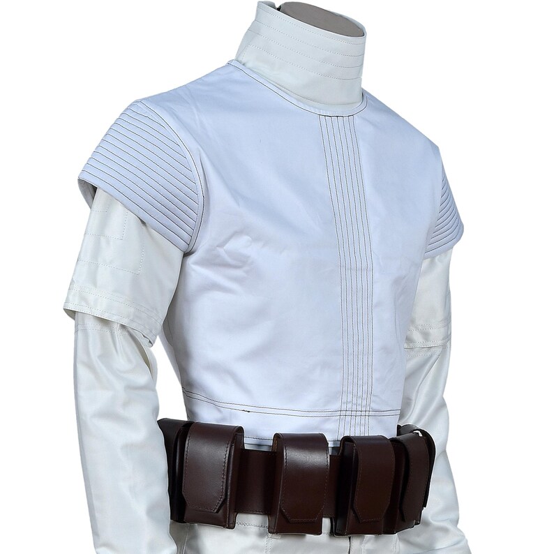 May include: White costume with a high collar and short sleeves. The top has vertical stitching and padded shoulders. A brown belt with multiple pouches is worn around the waist. The outfit appears to be a futuristic or sci-fi design.