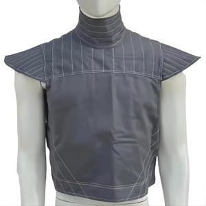 Op de afbeelding: Een grijze vest met een hoge kraag en schoudervullingen. De vest heeft witte verticale en horizontale stikseldetails. Het kledingstuk wordt op een mannequin getoond.