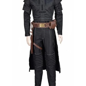 May include: Black costume with white stitching, featuring a long-sleeved top with shoulder accents and a matching pair of pants. The outfit includes a brown belt with a gold buckle, a holster, and a pouch. The costume is displayed on a mannequin.